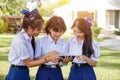 Group of Thai students looking a social network on tablet at school lawn with sun bright background Royalty Free Stock Photo