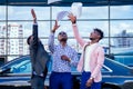 A group of their three successful African American businessmen in a stylish suit throw papers up against a skyscraper of Royalty Free Stock Photo