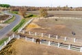 Group of thoroughbred horses walking and grazing in paddock near stable. Long evening afternoon shadow. Beautiful animals at farm Royalty Free Stock Photo