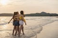 Group of three Asian young women walking on beach, friends happy relax having fun playing on beach near sea when sunset in evening Royalty Free Stock Photo