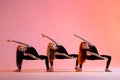 group of three ballet girls in black tight-fitting suits dancing on red background with their long hair down