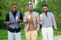 A group of three black men in stylish suits a meeting in a summer park. African-Americans friends hispanic businessman Royalty Free Stock Photo