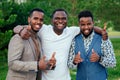 A group of three black men in stylish suits a meeting in a summer park. African-Americans friends hispanic businessman Royalty Free Stock Photo