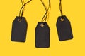 Group of three Blank black tags isolated on yellow background