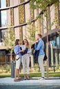 Group of three caucasian business people talking in front of a building. spontaneous chat