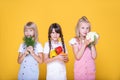 Group of three cute healthy school girls holding vegetables, lifestyle. Concept of healthy food for children. Proper balanced food Royalty Free Stock Photo