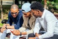 A group of three fashionable well-dressed cool African American guys students communicating on the street