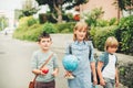 Group of three funny kids wearing backpacks walking back to school Royalty Free Stock Photo