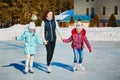 A group of three girls on a winter skating rink. Roll and laugh. Skating rink in nature. Royalty Free Stock Photo