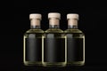 Group of three glass bottles for cosmetic, perfume, drink with black label, cork, yellow liquid on dark black background, mock up.