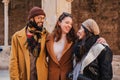 Group of three happy multiracial tourist friends having fun together at weekend trip. Young people walking and smiling Royalty Free Stock Photo