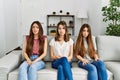 Group of three hispanic girls sitting on the sofa at home depressed and worry for distress, crying angry and afraid