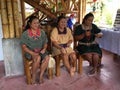 Group of three indigenous women of Cofan nationality weaving handicrafts in their home in the Amazon rainforest