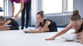 A group of three little girls train on a white mat in a sports club. Gymnastics concept