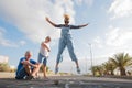 Group of three people having fun together in the street playing at the hopscotch - two seniors and one eautiful woman jumping