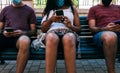 Group of three people with mask in bank using mobile phone, social distance concept with face mask