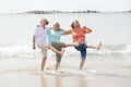 Group of three senior mature retired women on their 60s having fun enjoying together happy walking on the beach smiling playful Royalty Free Stock Photo