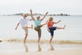 Group of three senior mature retired women on their 60s having fun enjoying together happy walking on the beach smiling playful Royalty Free Stock Photo