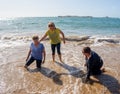 Group of three senior women laughing as falling down in the water on beach. Humor senior health Royalty Free Stock Photo