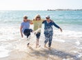 Group of three senior women walking having having fun on beach. Friendship and healthy lifestyle Royalty Free Stock Photo