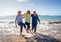 Group of three senior women walking having having fun on beach. Friendship and healthy lifestyle Royalty Free Stock Photo