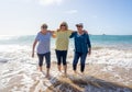 Group of three senior women walking having having fun on beach. Friendship and healthy lifestyle Royalty Free Stock Photo