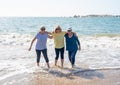 Group of three senior women walking having having fun on beach. Friendship and retirement lifestyle Royalty Free Stock Photo