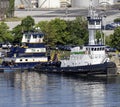 Group of three similar tugboats by a port pier in an industrial district along the Patapsco River near the downtown area of this Royalty Free Stock Photo