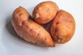 Group of three sweet potatos close up, light background Royalty Free Stock Photo