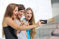 Group of three teenager girls amazed watching the smart phone