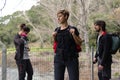 Group of three, two women and a man, standing pensively with trekking backpacks