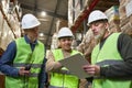 Group of three workers in warehouse holding clipboard Royalty Free Stock Photo