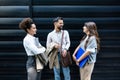 Group of three young business people experts in marketing telecommuting financial and strategy, talking outside office building. Royalty Free Stock Photo