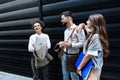 Group of three young business people experts in marketing telecommuting financial and strategy, talking outside office building. Royalty Free Stock Photo