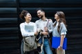 Group of three young business people experts in marketing telecommuting financial and strategy, talking outside office building. Royalty Free Stock Photo