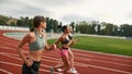 Group of three young professional female runners running together on track field at the stadium Royalty Free Stock Photo