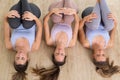Group of three young sporty attractive women in yoga studio, lying on the floor, stretching and relaxing after the Royalty Free Stock Photo