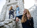 Group of three young Stylish nice girls in pantsuit costumes sitting on a stairs near white construction Royalty Free Stock Photo