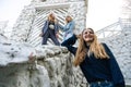 Group of three young Stylish nice girls in pantsuit costumes sitting on a stairs near white construction Royalty Free Stock Photo