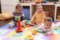 Group of toddlers playing with toys sitting on floor at kindergarten Royalty Free Stock Photo