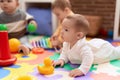 Group of toddlers playing with toys sitting on floor at kindergarten Royalty Free Stock Photo