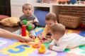 Group of toddlers playing with toys sitting on floor at kindergarten Royalty Free Stock Photo