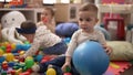 Group of toddlers playing with toys sitting on floor at kindergarten Royalty Free Stock Photo