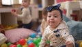 Group of toddlers playing with toys sitting on floor at kindergarten Royalty Free Stock Photo