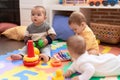 Group of toddlers playing with toys sitting on floor at kindergarten Royalty Free Stock Photo