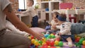 Group of toddlers playing with toys sitting on floor at kindergarten Royalty Free Stock Photo