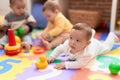 Group of toddlers playing with toys sitting on floor at kindergarten Royalty Free Stock Photo