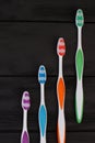 Group of tooth brushes on black wooden table. Royalty Free Stock Photo