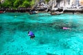 Group of Tourism on trip in purple or violet and life jacket with diving mask is snorkeling among many Indo-Pacific sergeant fish