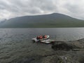 Group of tourist hikers on motor boat at pier prepar to crossing Teusajaure lake at Kungsleden hiking trail. Lapland mountains Royalty Free Stock Photo